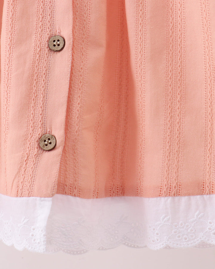 Peach dress bodice with vertical stitching texture, two button placket, and lace hem