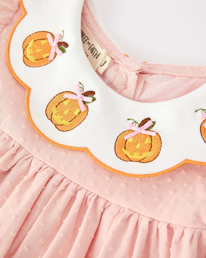 Pink dress bodice detail with orange pumpkin appliques and ruffled neckline