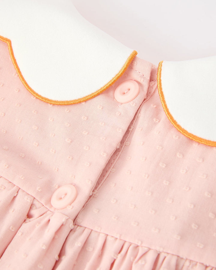 Pink dress neckline with orange-trimmed Peter collar and raised dot texture
