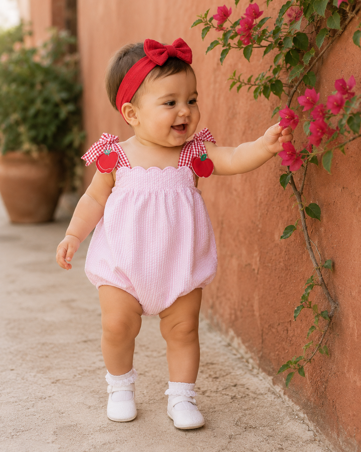 Baby girl is looking at some pink flowers