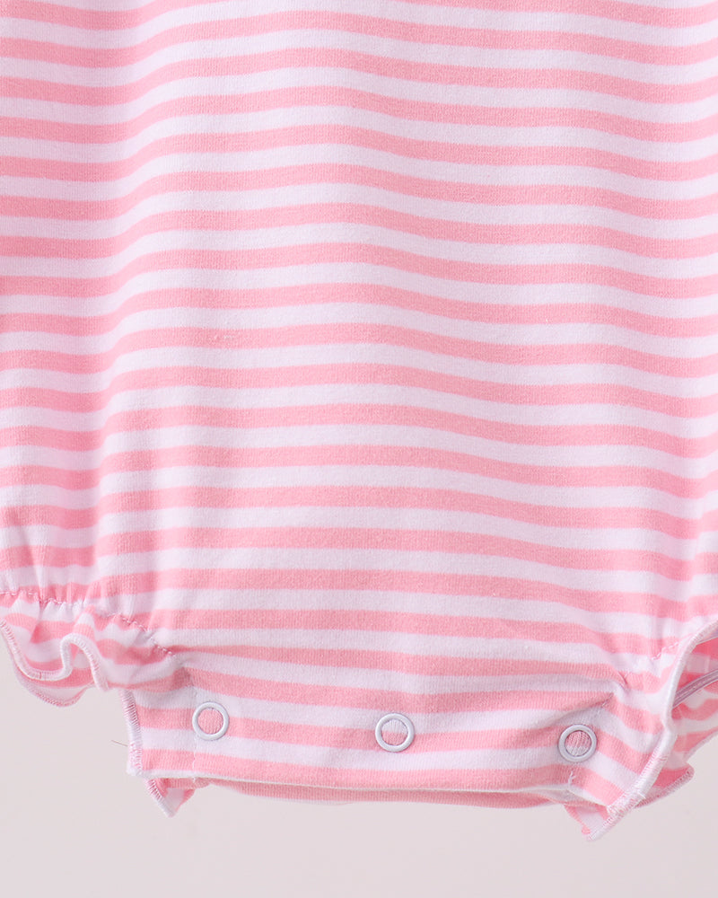 Close-up of a pink and white striped baby romper with ruffled leg openings and three snap closures at the crotch.