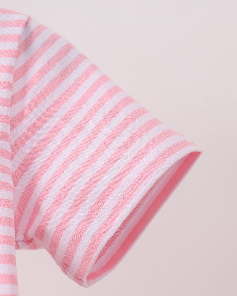 Close-up of a pink and white striped short-sleeve garment, showing the sleeve cuff and fabric texture against a pale pink background.