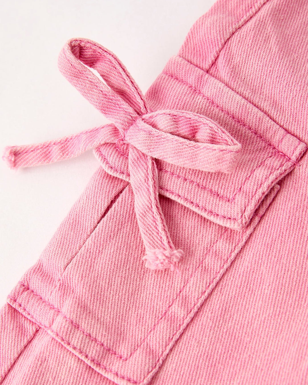 Light pink jeans with bow-tied cargo pocket detail