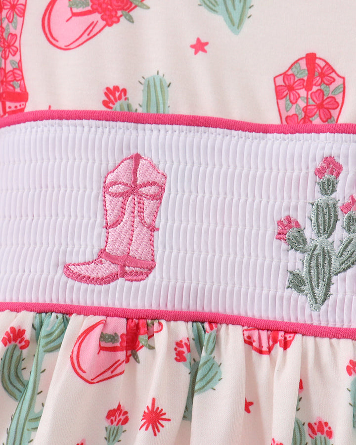 Fabric with pink cowboy boot design and cactus pattern on a white background