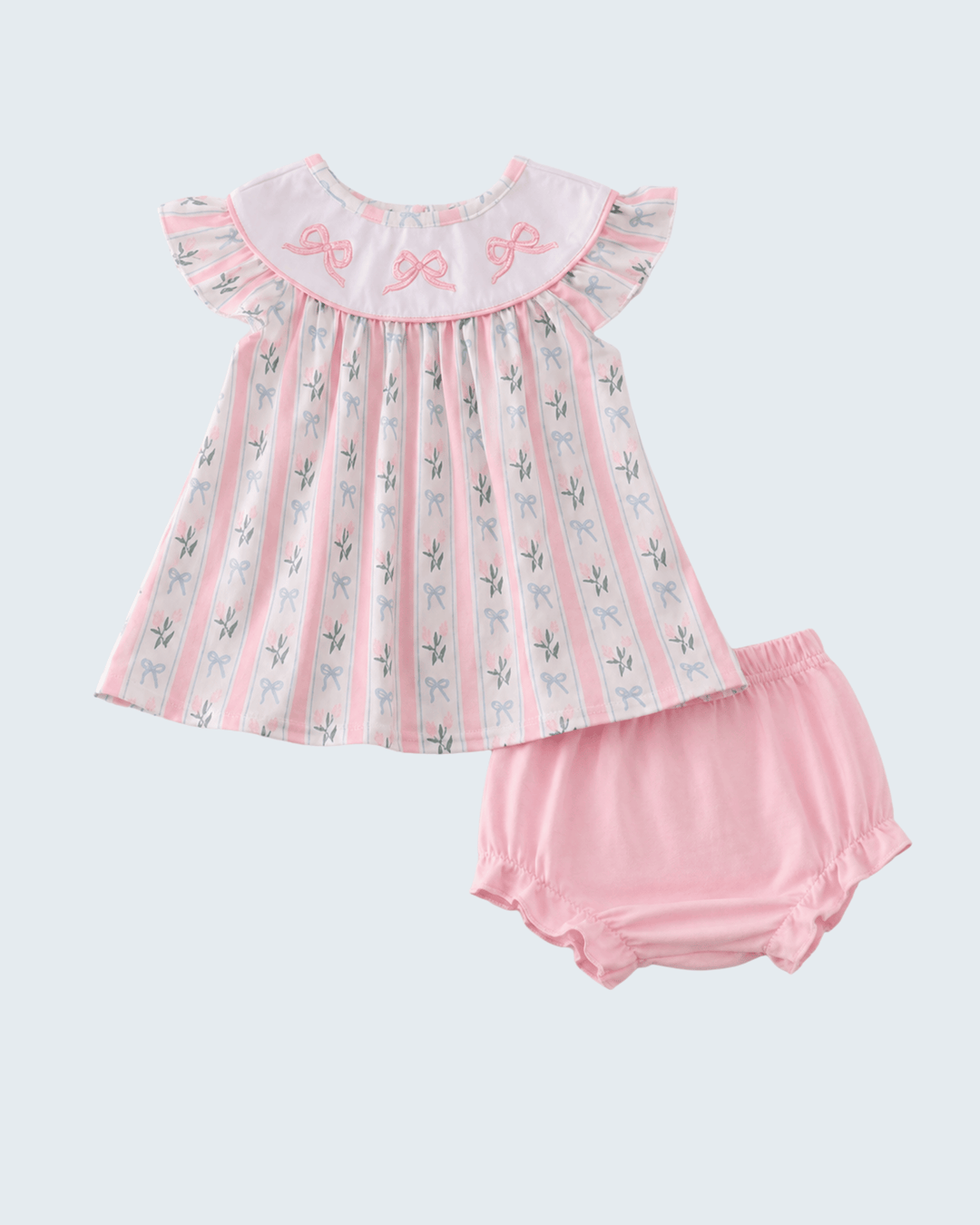 Baby dress and bloomers set with floral pattern on a light gray background