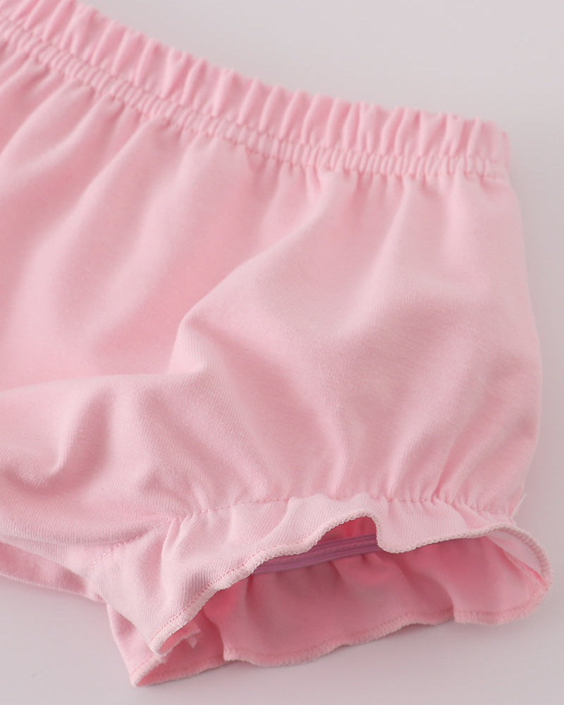 Pink baby bloomers on a light gray background