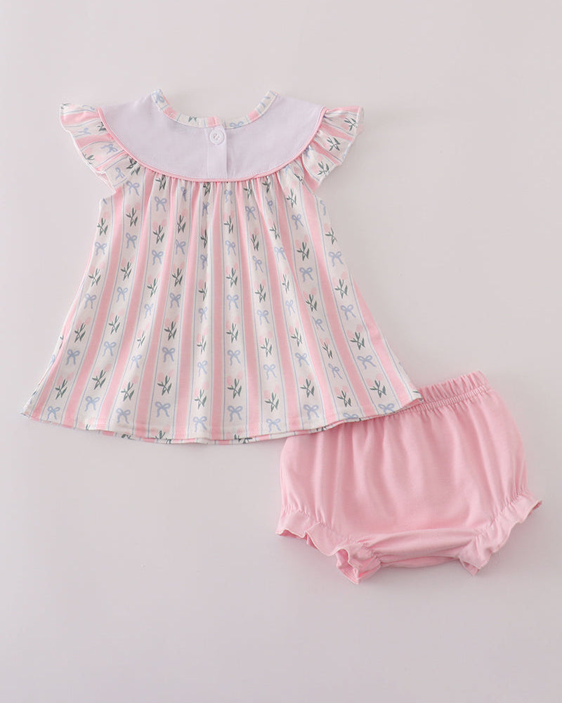 Baby dress with floral pattern and matching bloomers on a light gray background