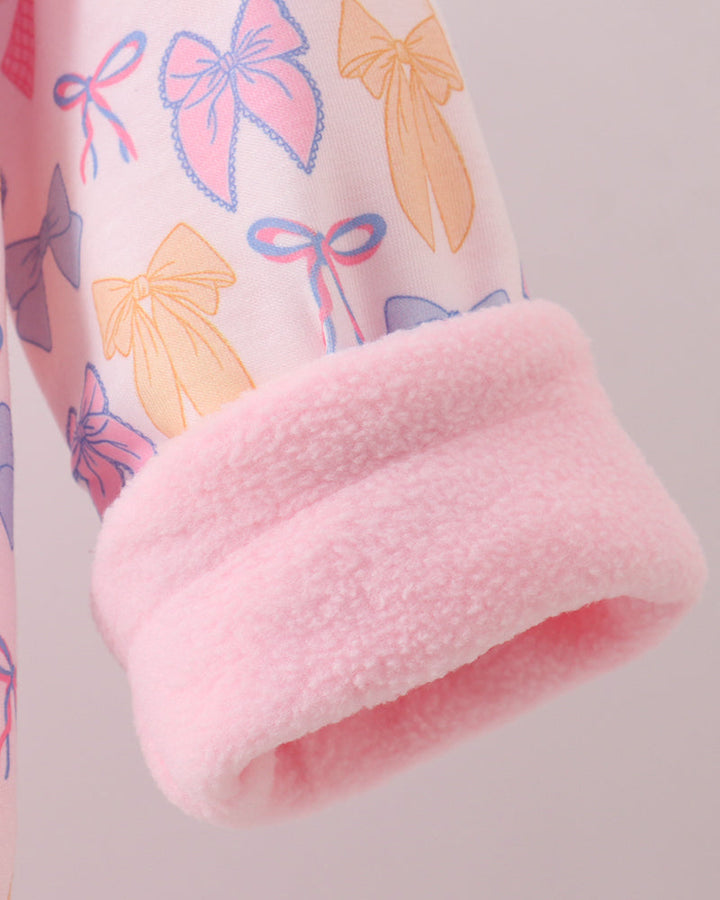 Pink sherpa-lined cuff detail on bow-pattern fleece hoodie coat sleeve