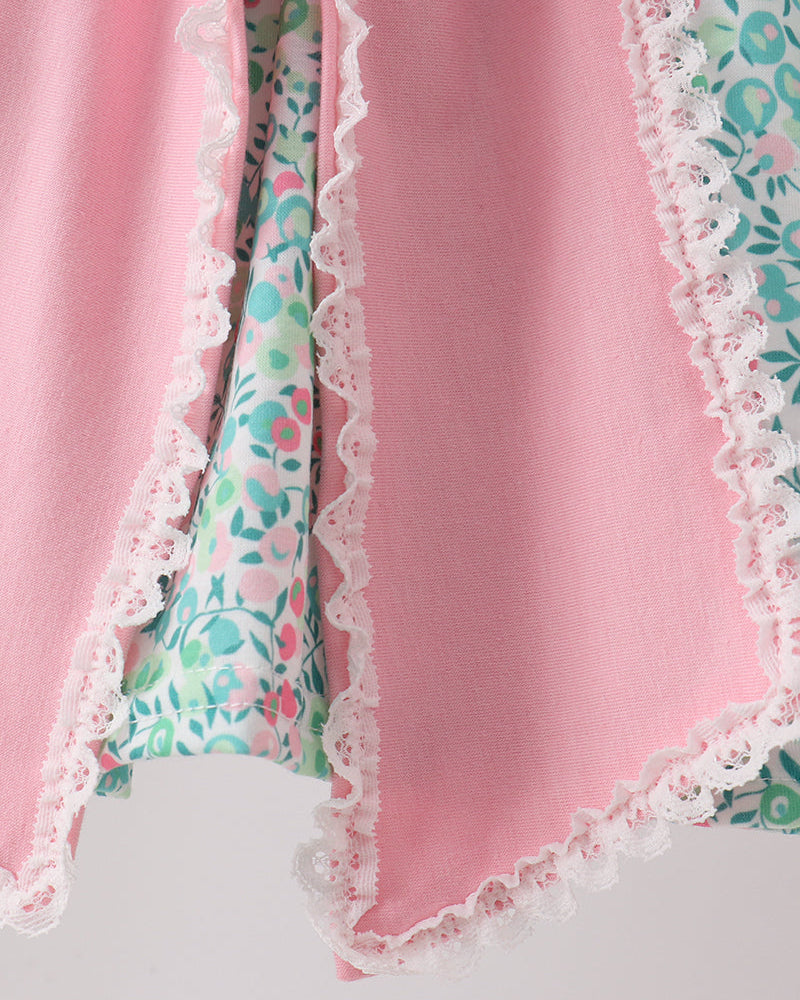 Pink fabric with floral trim and lace on a light gray background