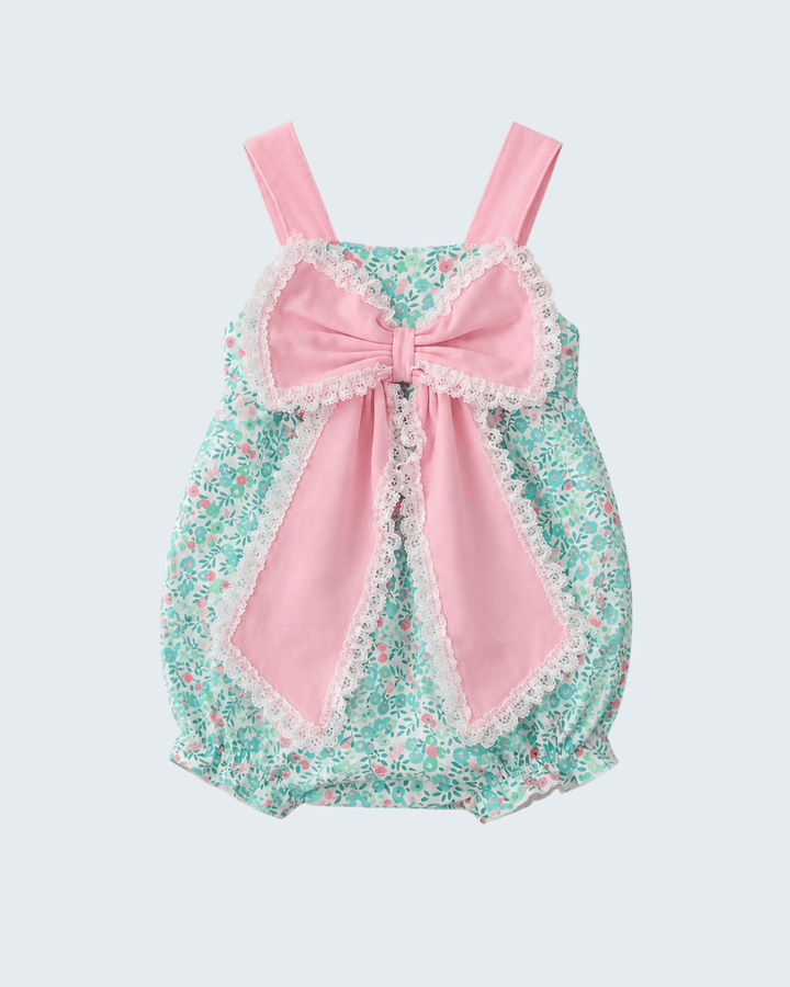 Baby romper with floral pattern and pink bow on a light gray background