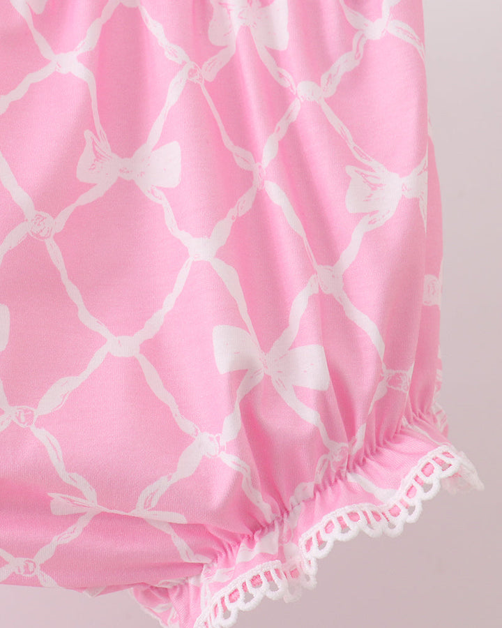 Pink bloomers with white bow pattern on a light pink background