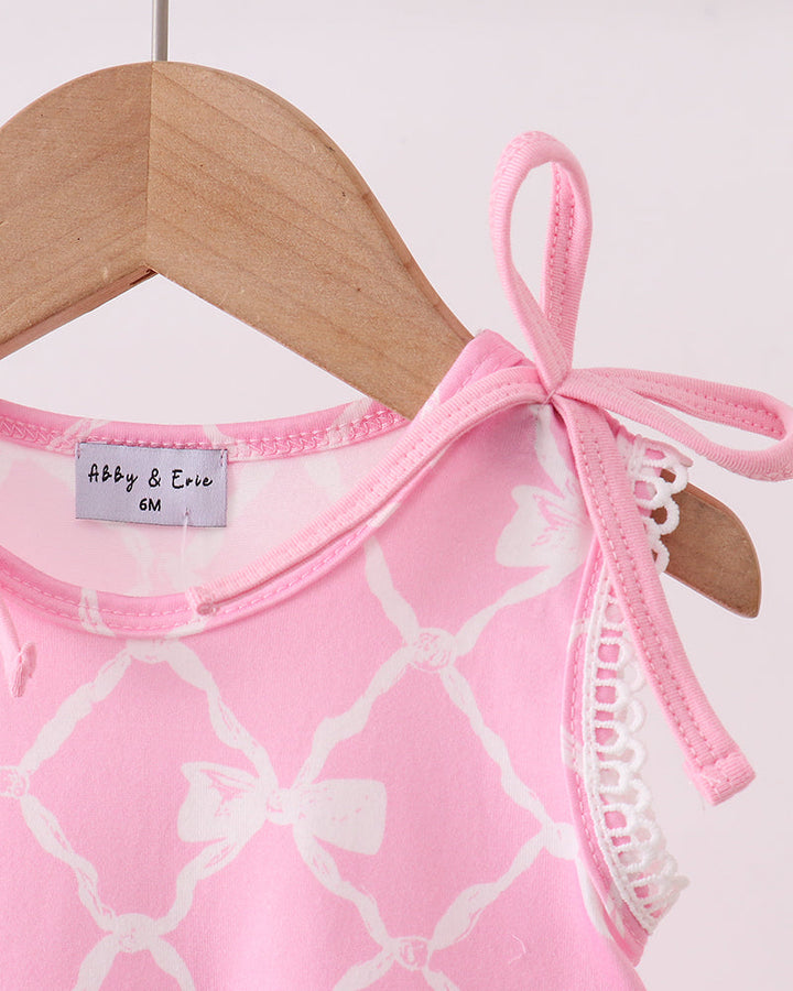 Pink and white patterned dress with lace trim on a hanger