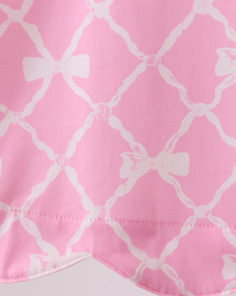 Close-up of pink fabric with white bow pattern
