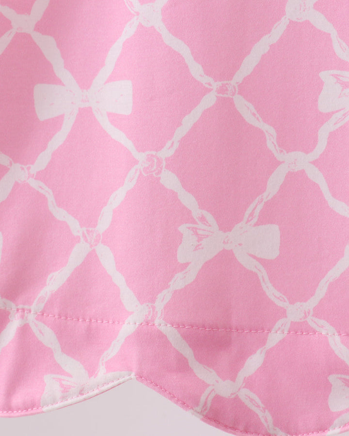 Close-up of pink fabric with white bow pattern