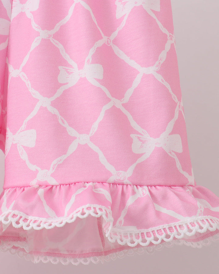 Pink shorts with white lattice pattern and lace trim on a light gray background