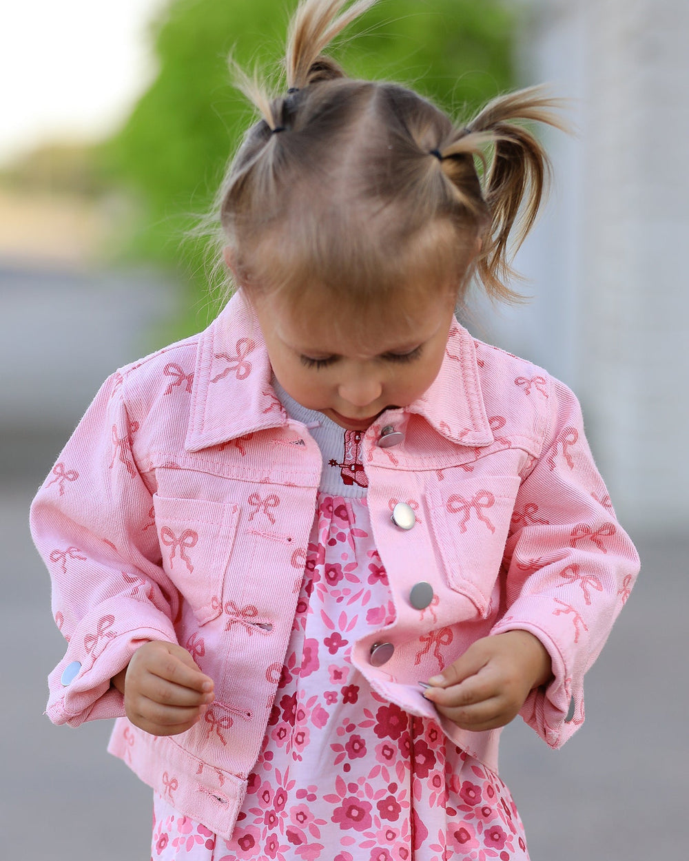 Pink girls denim jacket with bow print, button front and chest pockets