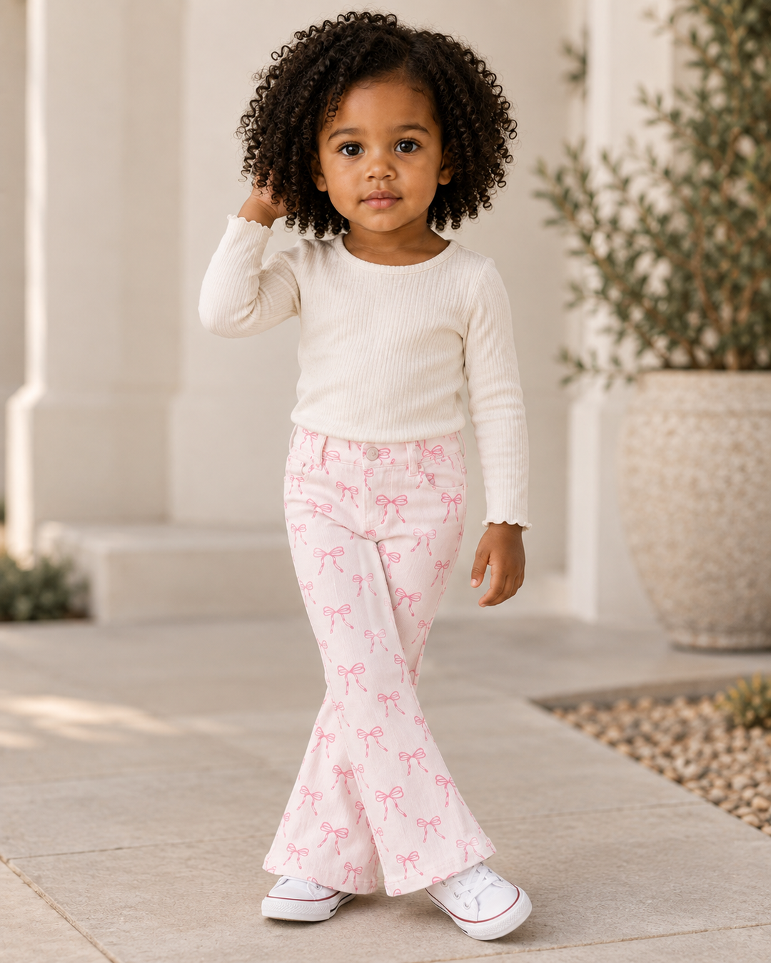 Kids pink bow print flare jeans, bell-bottom silhouette and elastic waist