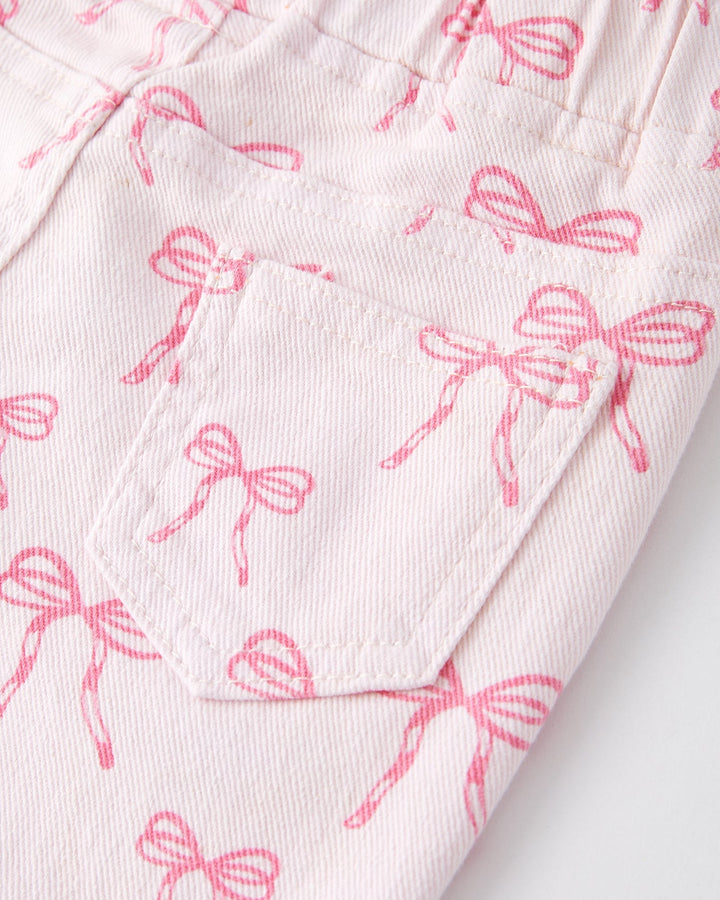 Girls flared jeans close-up: pink bow print fabric with stitched seams