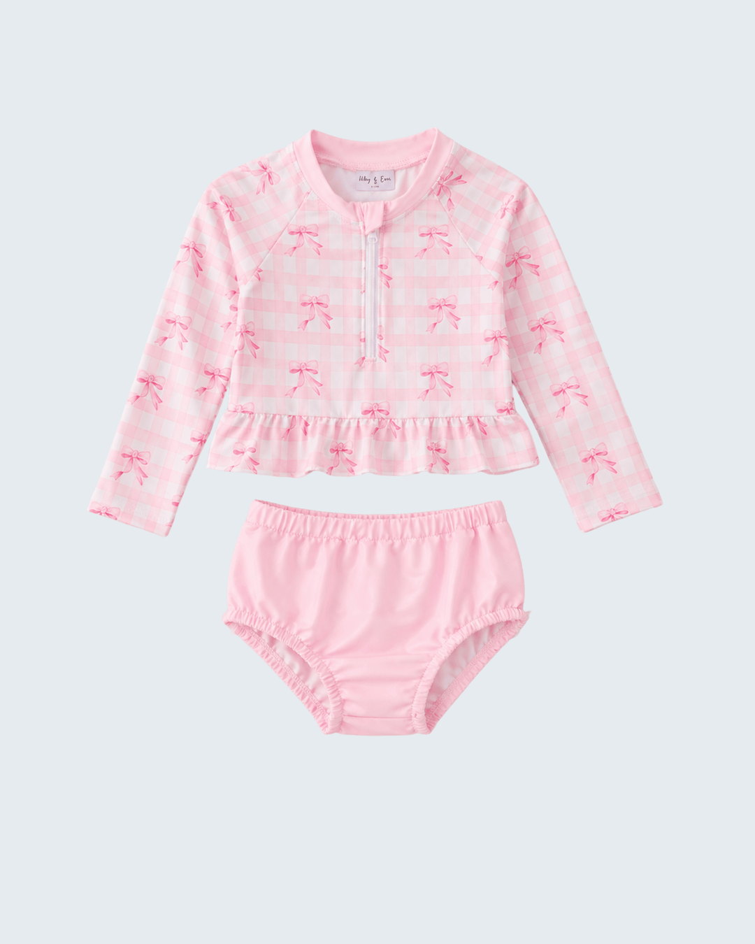 Pink swimsuit for girls with long-sleeve top and bloomers on a light gray background