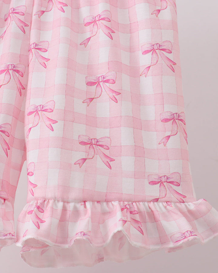 Pink shorts with bow pattern on a light gray background