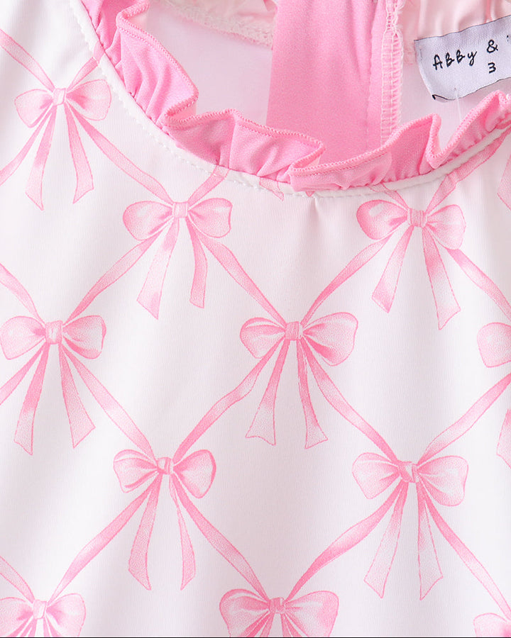 White garment with pink bow pattern and a visible label on a white background