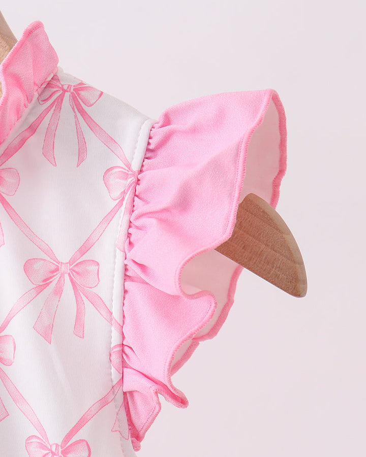 Close-up of a pink and white outfit with ruffled details on a light gray background