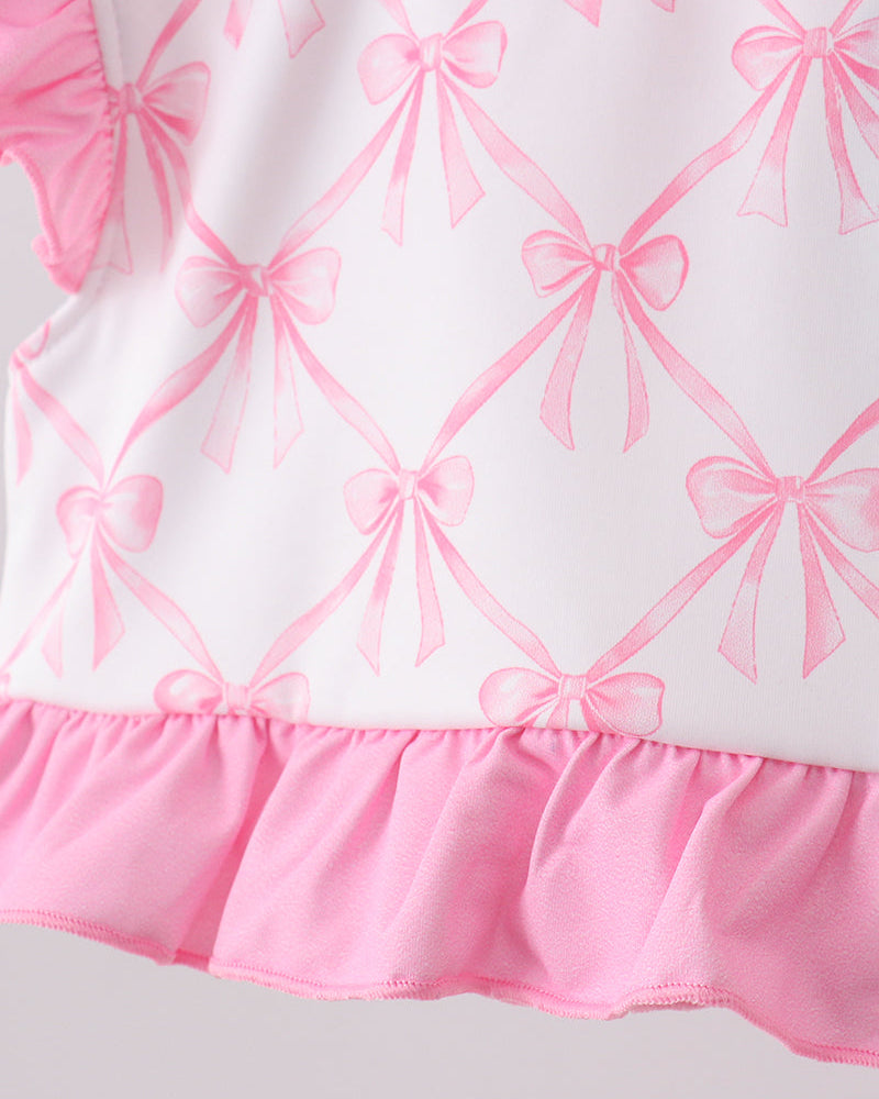 Close-up of a swimsuit with pink bow pattern on a white background
