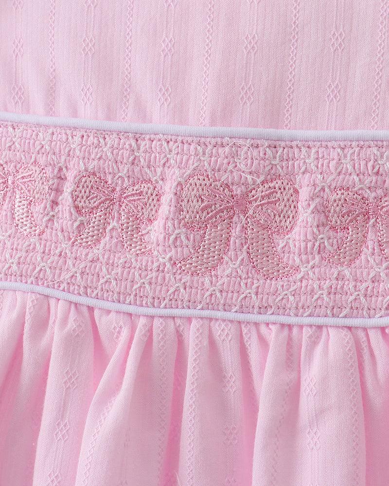 Close-up of a pink dress with smocked details