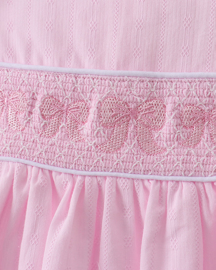 Close-up of a pink dress with smocked details