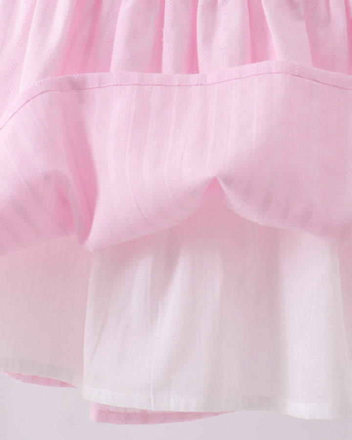 Close-up of a pink fabric with a textured pattern on a white background