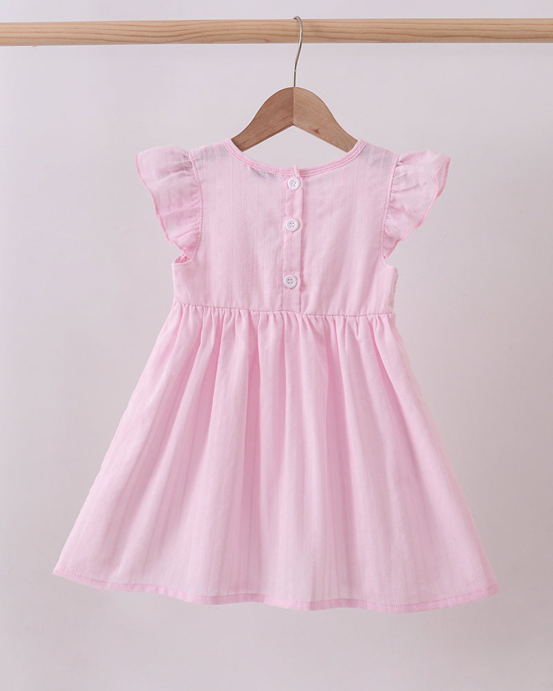 Pink dress on a wooden hanger against a light gray background