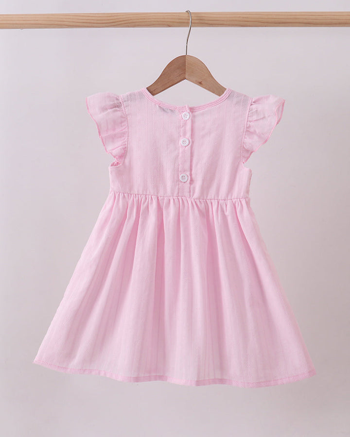 Pink dress on a wooden hanger against a light gray background