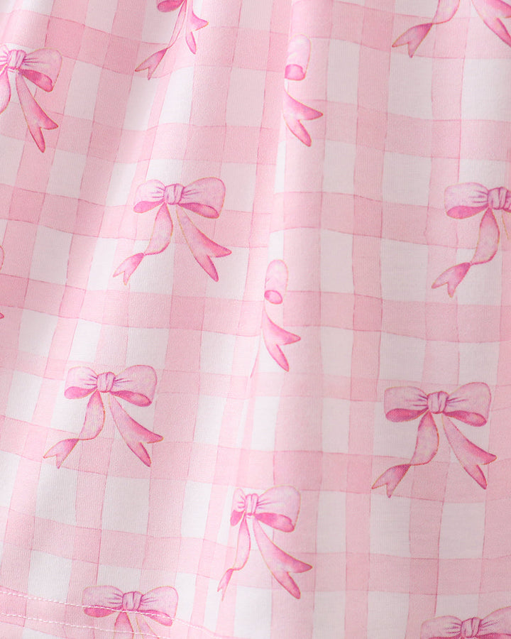 Pink checkered fabric with bow patterns on a white background