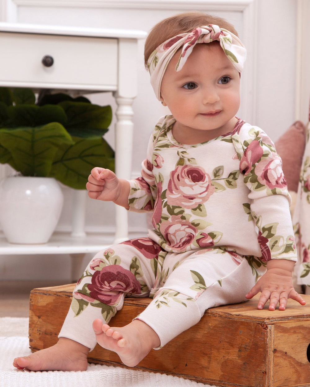 Floral cotton baby romper with long sleeves, pink rose print and footed legs