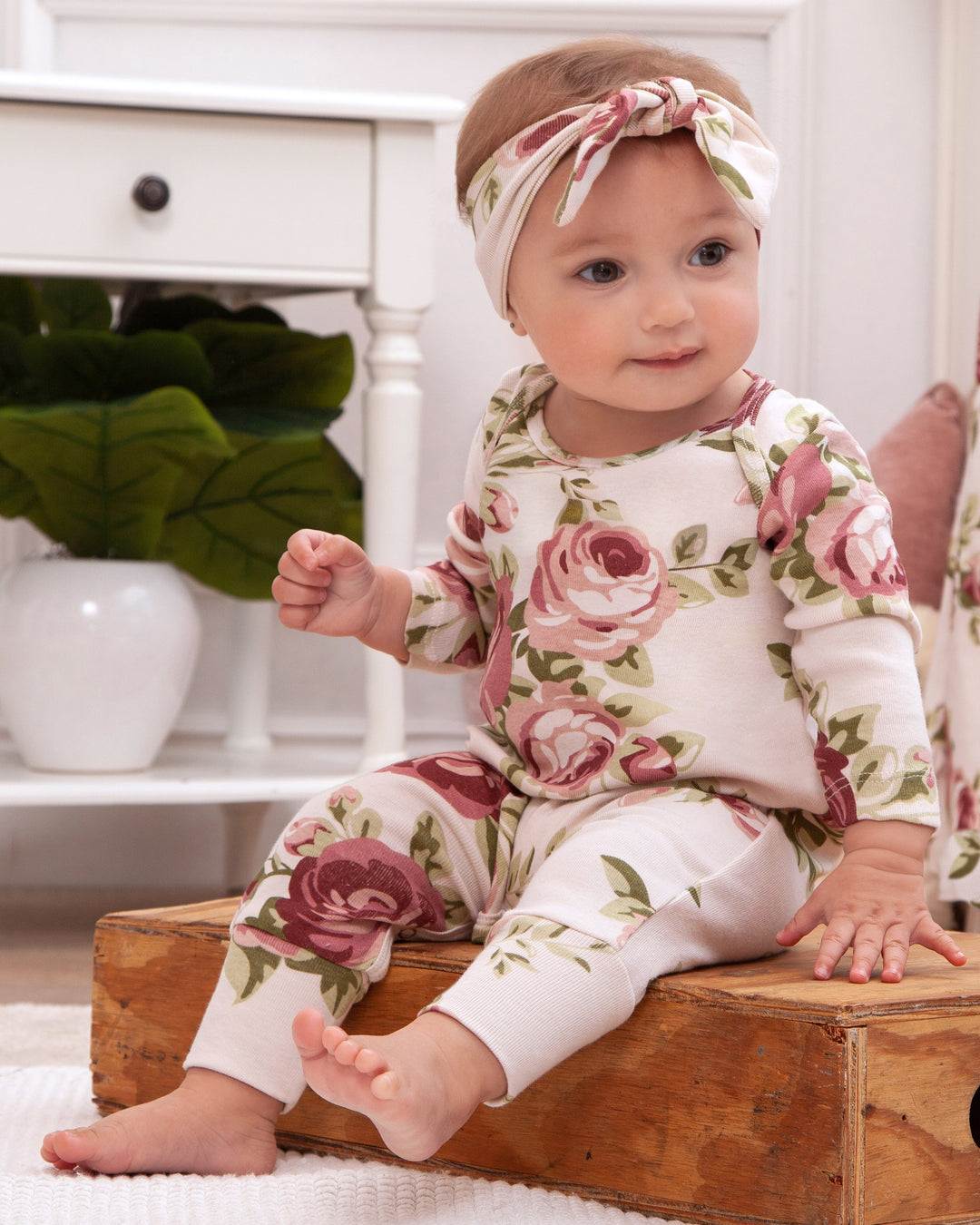 Floral cotton baby romper with long sleeves, pink rose print and footed legs