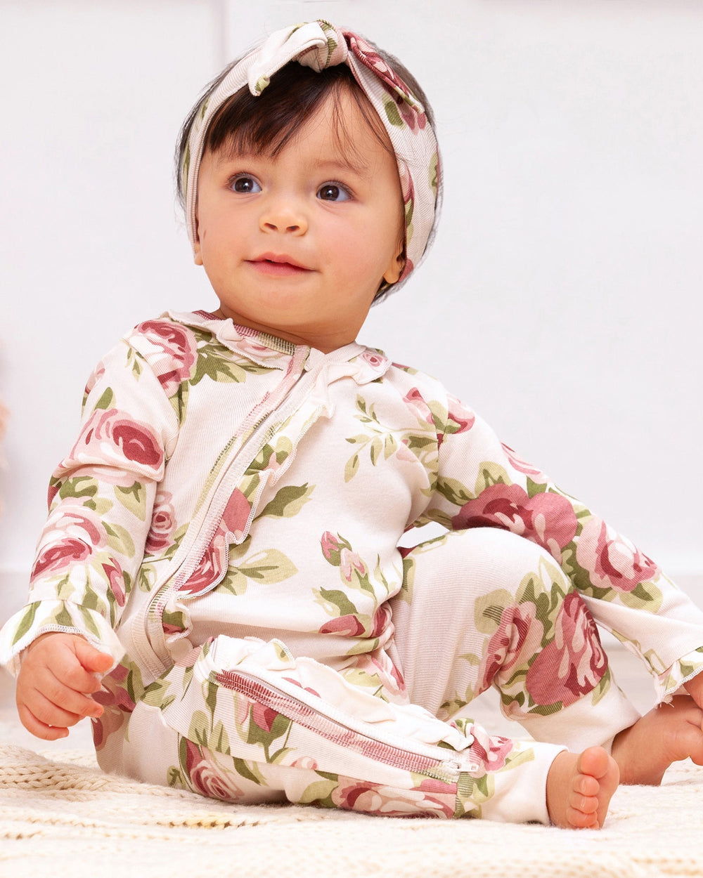 Floral zip-front baby romper with long sleeves and footed legs, pink and green