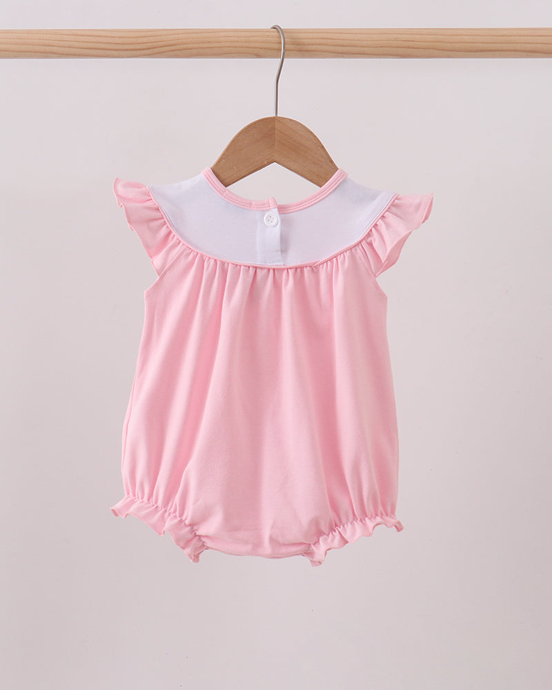 Pink baby romper with white collar on a wooden hanger against a light gray background