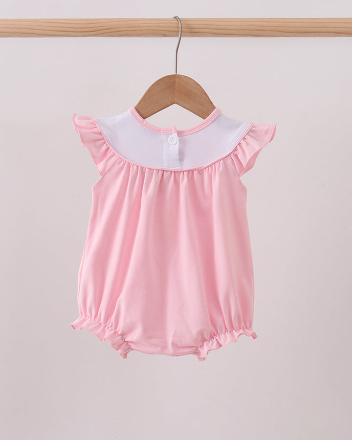 Pink baby romper with white collar on a wooden hanger against a light gray background