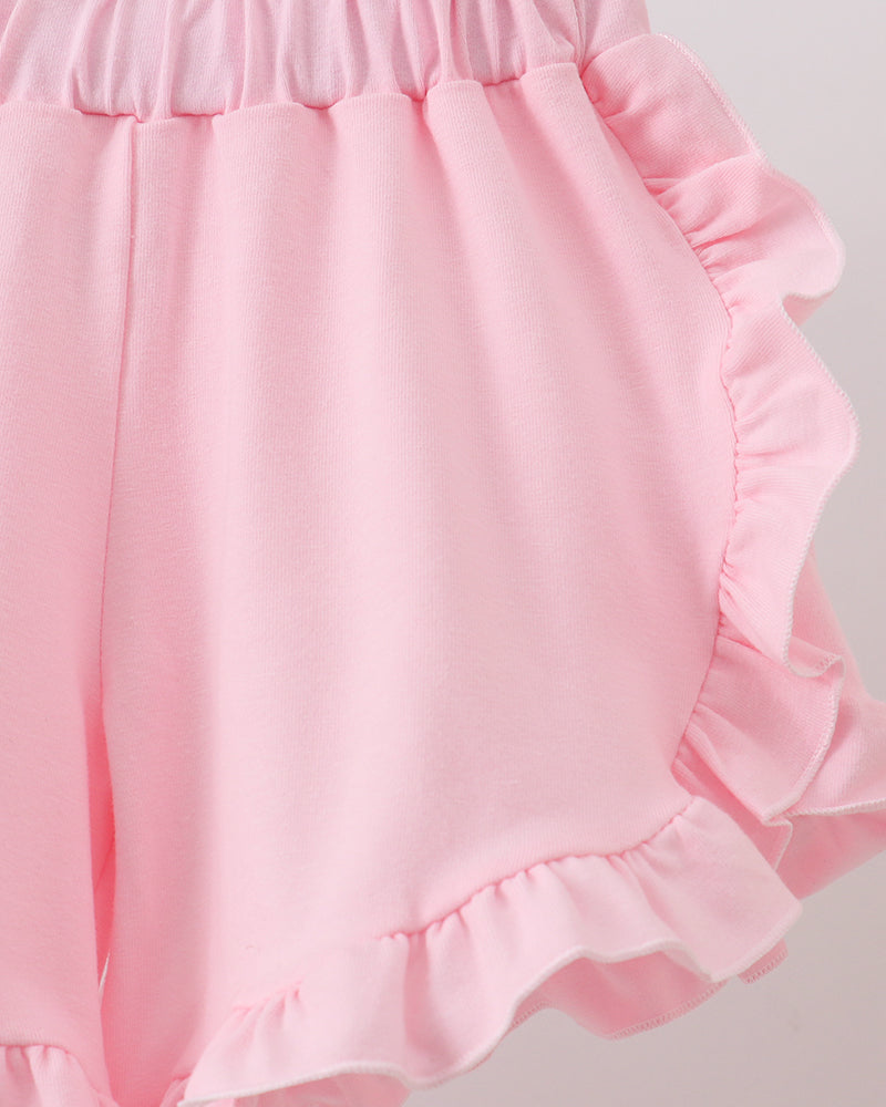 Pink ruffled shorts on a light gray background