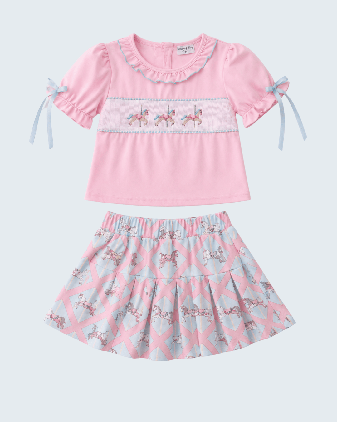 Pink top and skirt set with horse pattern on a white background