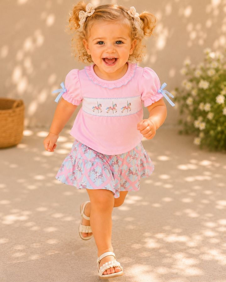 Child wearing a pink top and floral skort running outdoors.