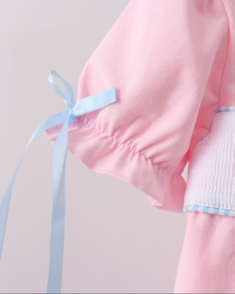 Pink garment with a blue ribbon on a light gray background