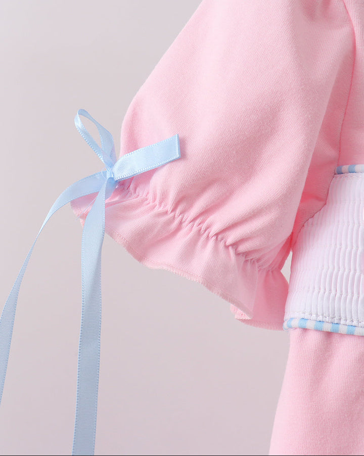 Pink garment with a blue ribbon on a light gray background