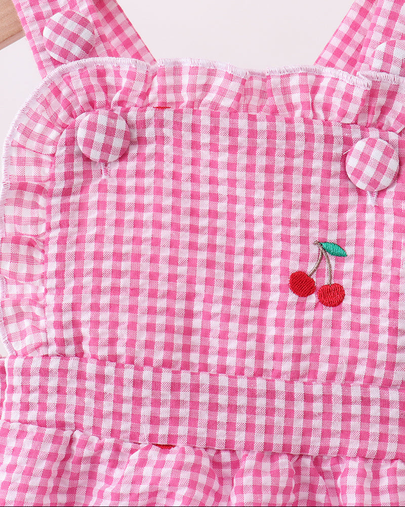 Pink gingham dress with cherry embroidery on a white background
