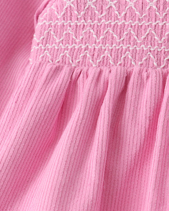 Pink corduroy dress with smocked waist and pleated skirt