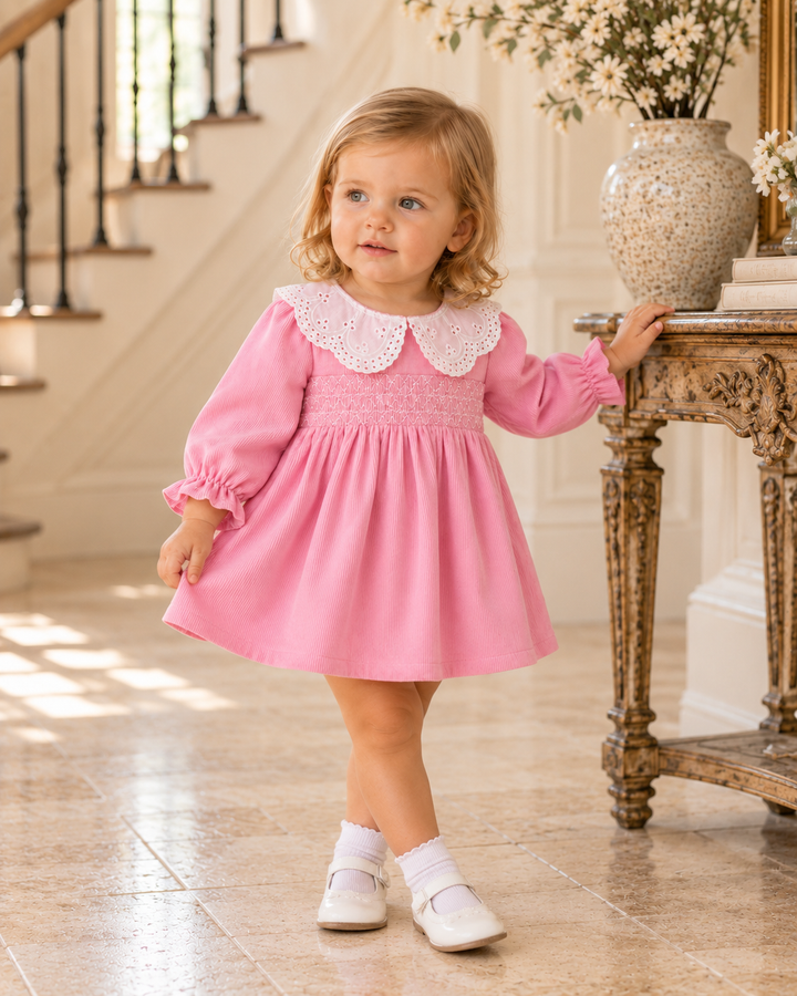 Pink corduroy dress on child with lace collar and smocked bodice