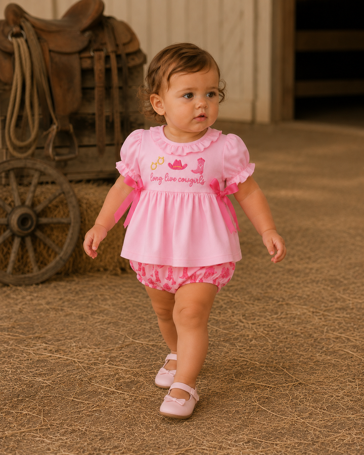 A toddler girl wearing a pink short-sleeve ruffled dress with &