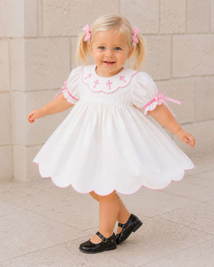 A toddler girl wearing a white baby girl&