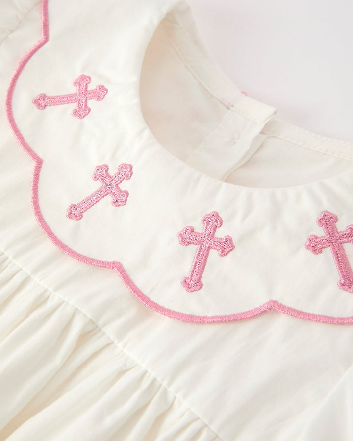 Girls cream dress neckline with pink cross embroidery and scalloped pink piping