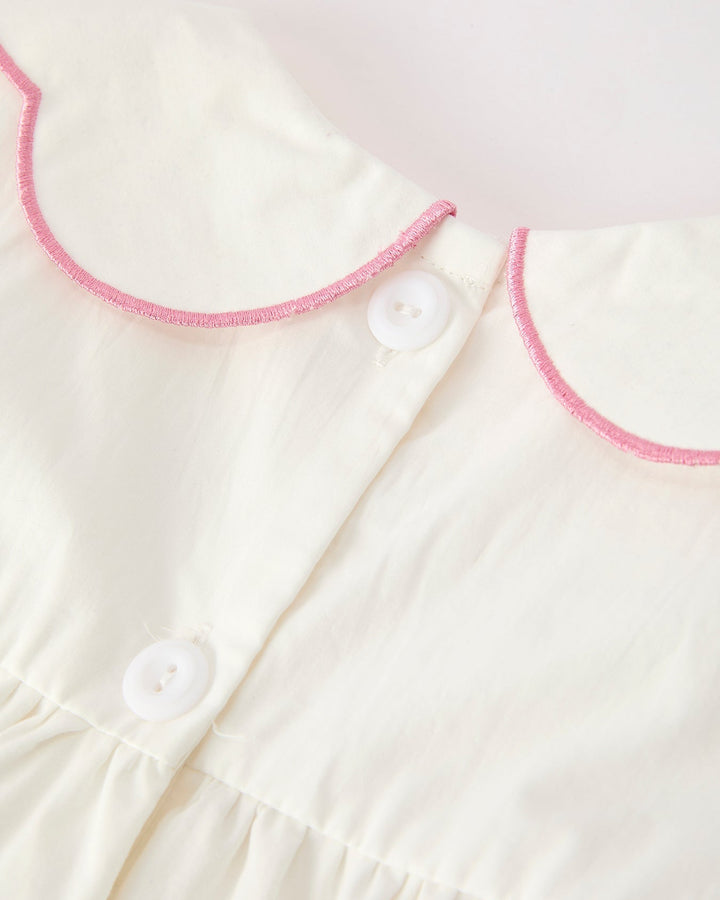 Girls cream christening dress with pink-trim button placket and Peter Pan collar